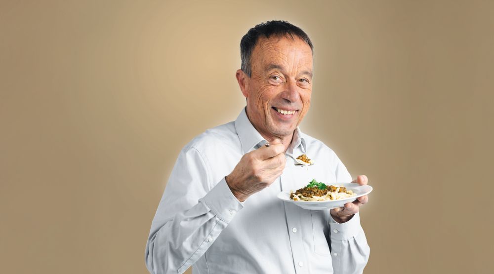 BaWü is(s)t fair. Ein älterer Mann isst lächelnd Linsen mit Spätzle.