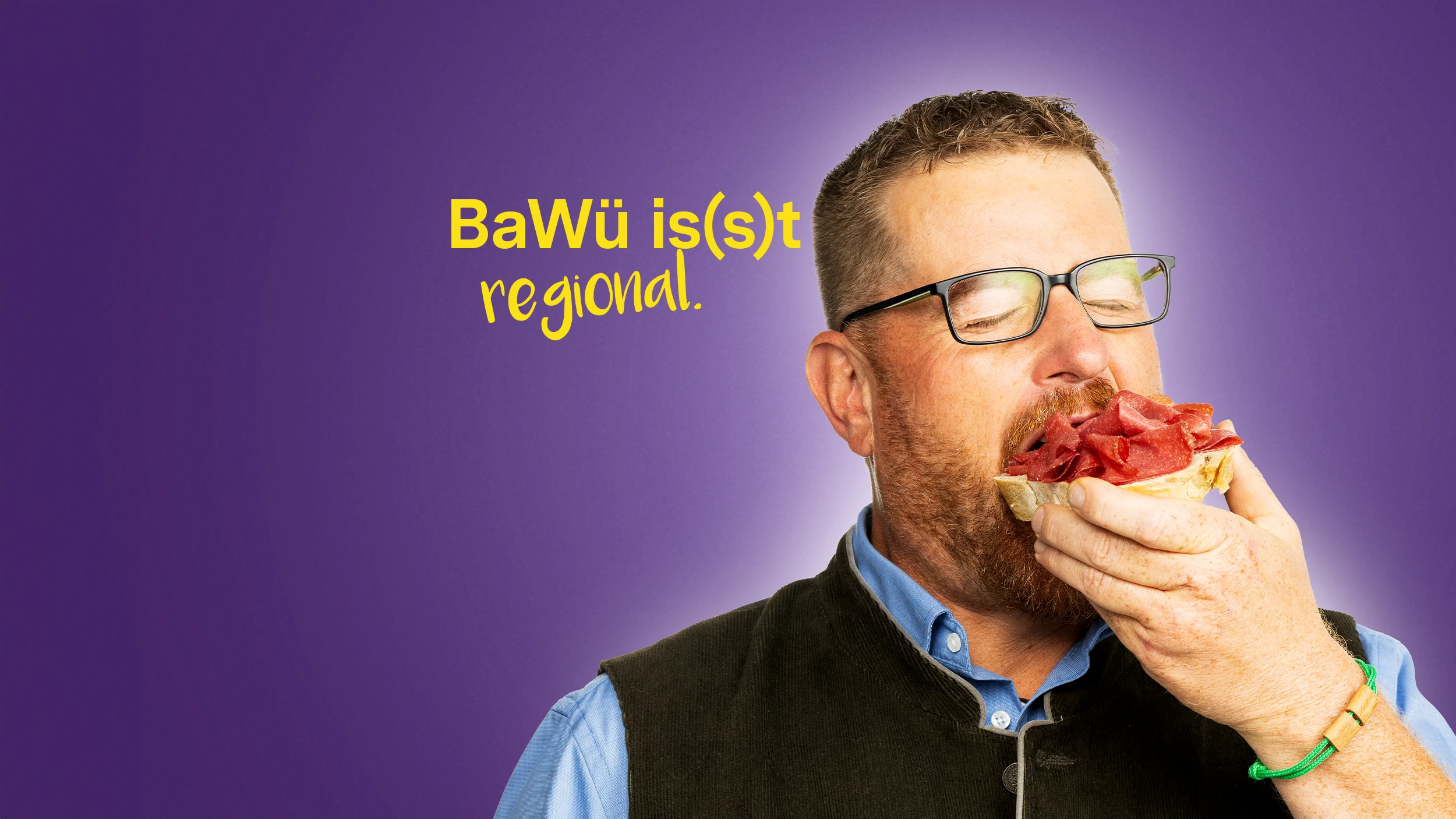 BaWü is(s)t regional. Ein Mann beißt herzhaft in ein mit Salami belegtes Brot.