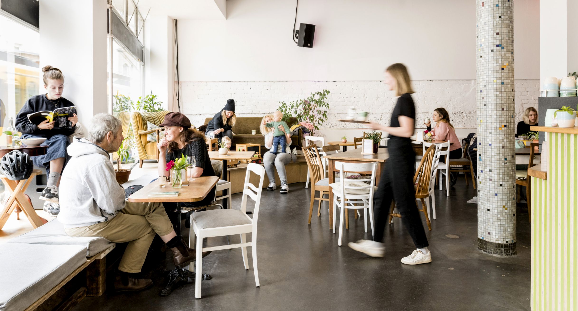 Menschen sitzen in einem Café, essen und unterhalten sich