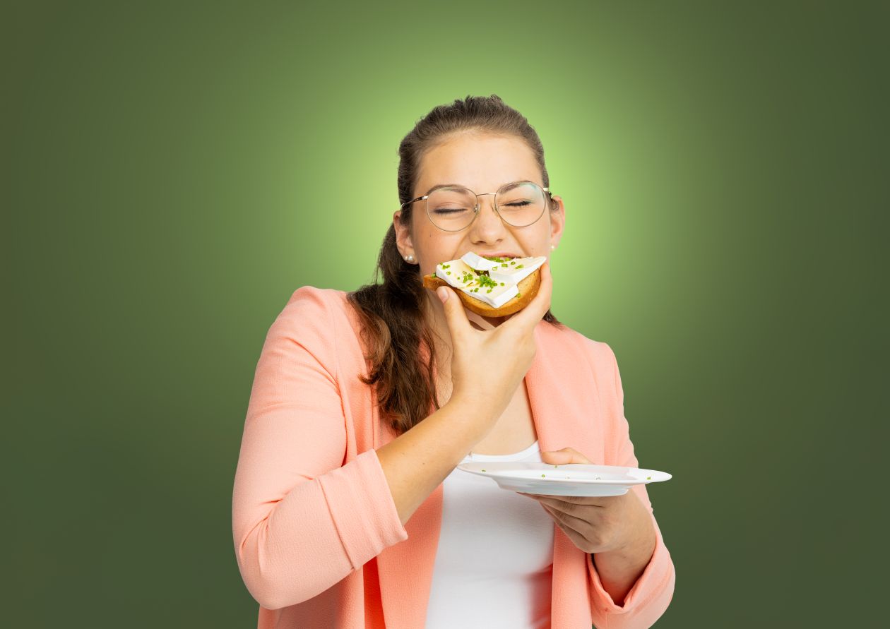 BaWü is(s) vielfältig. Eine junge Frau beißt mit geschlossenen Augen in ein Camembert-Brot.