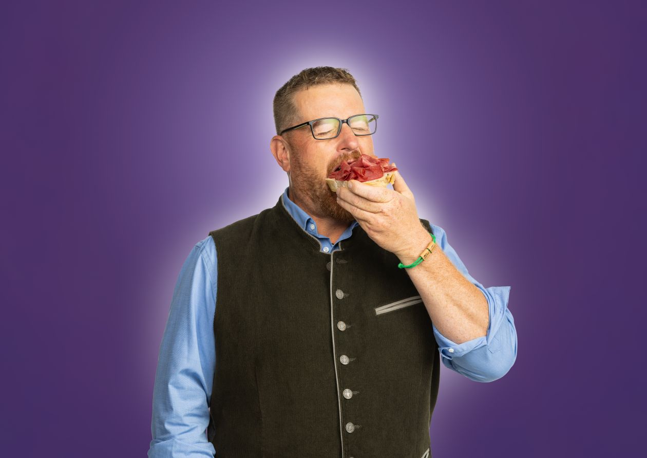 BaWü is(s)t regional. Ein Mann beißt herzhaft in ein mit Salami belegte Brötchenhälfte
