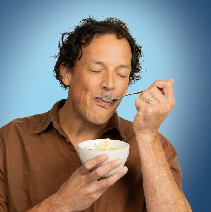 Ein Mann isst genüsslich und mit geschlossenen Augen Müsli.