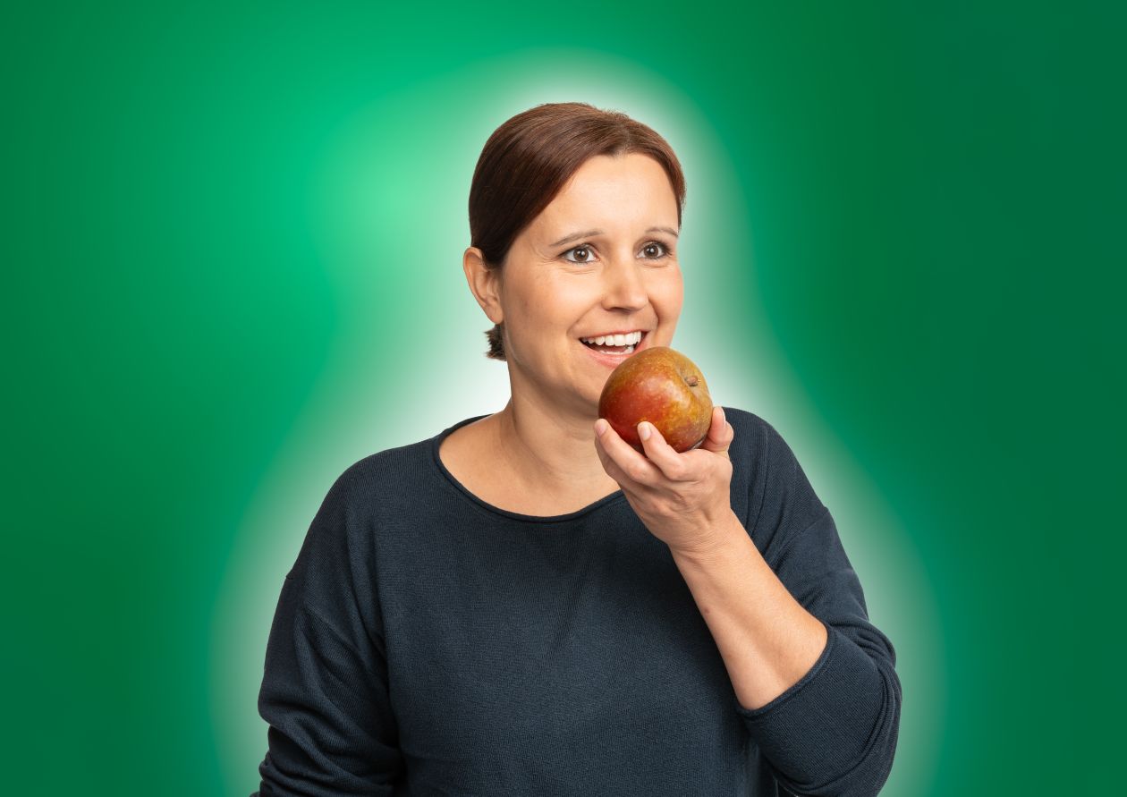 BaWü is(s)t clever. Eine junge Frau beißt herzhaft in einen Apfel